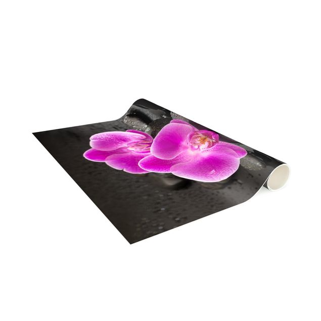 tappeti con fiori Fiore di orchidea rosa su pietra con gocce